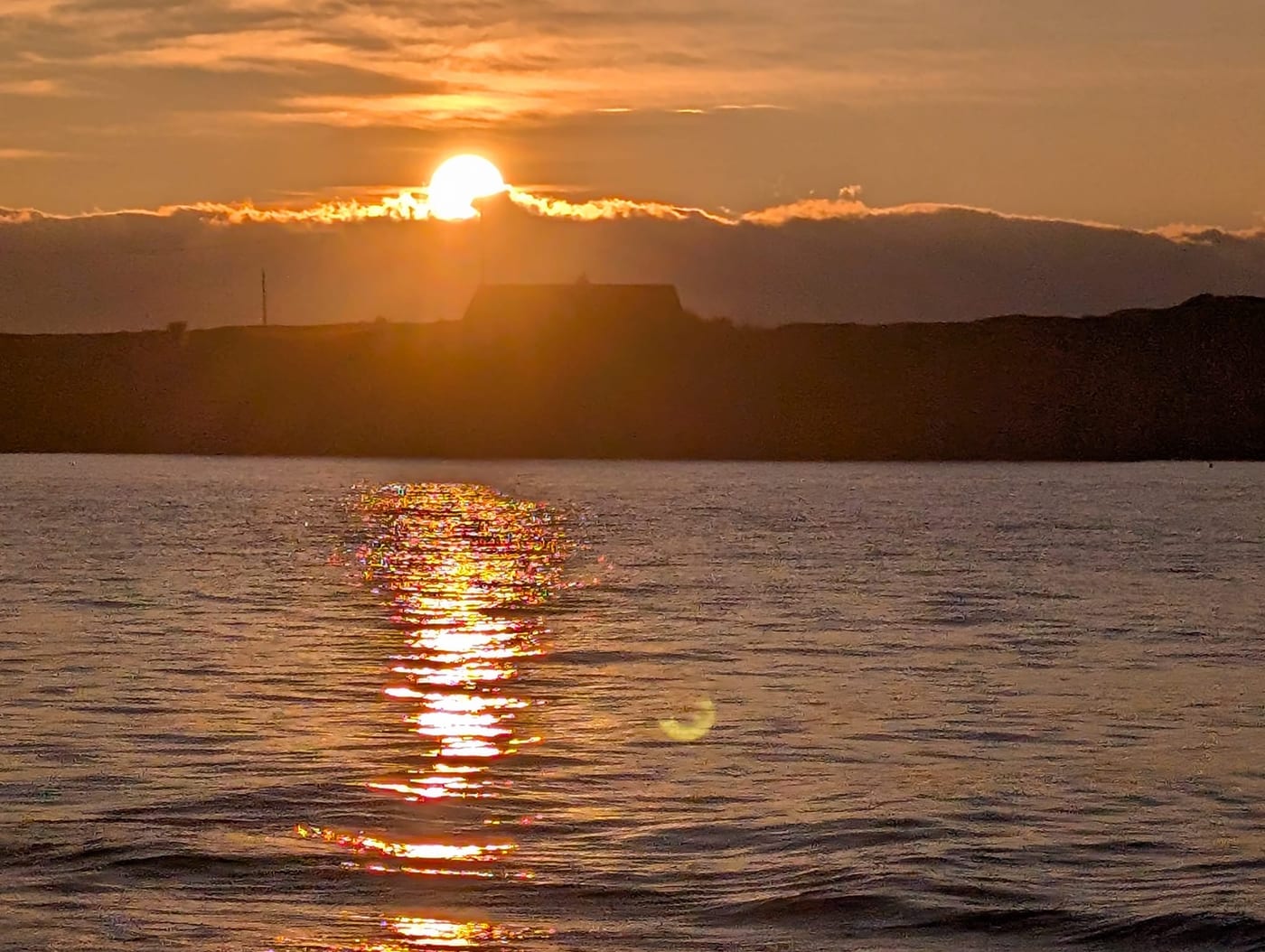 Two people walking on a North Wales beach at sunset