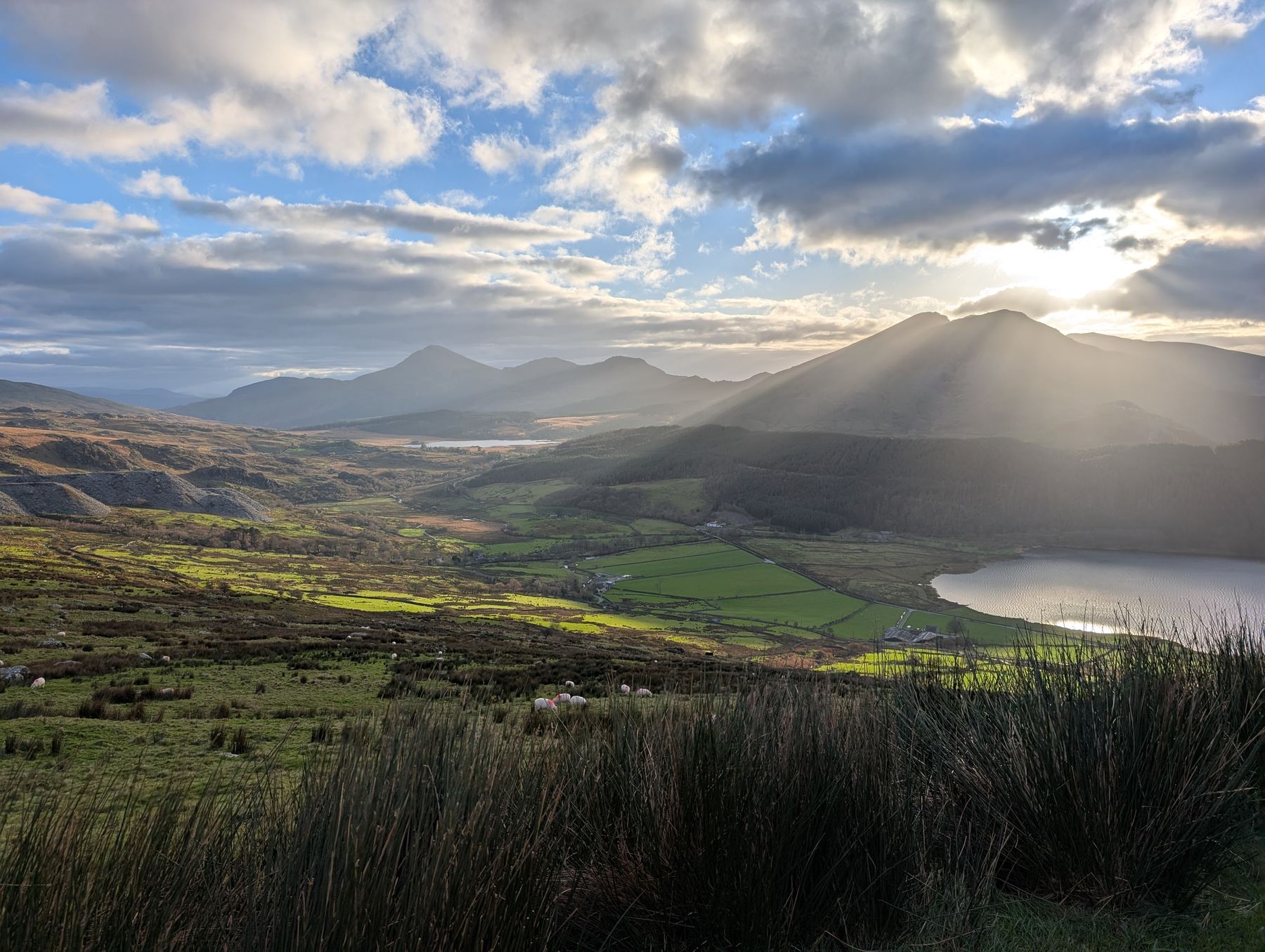 Sunbeams breaking through cloud over the mountains and lakes of Eryri